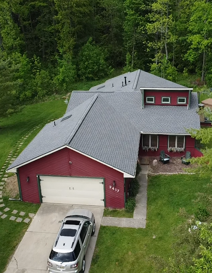 a house with a garage and a car parked in front of it Titan Roofing & Exteriors – Expert Roofing, Siding, and Gutter Installation Services for Durable Home Protection